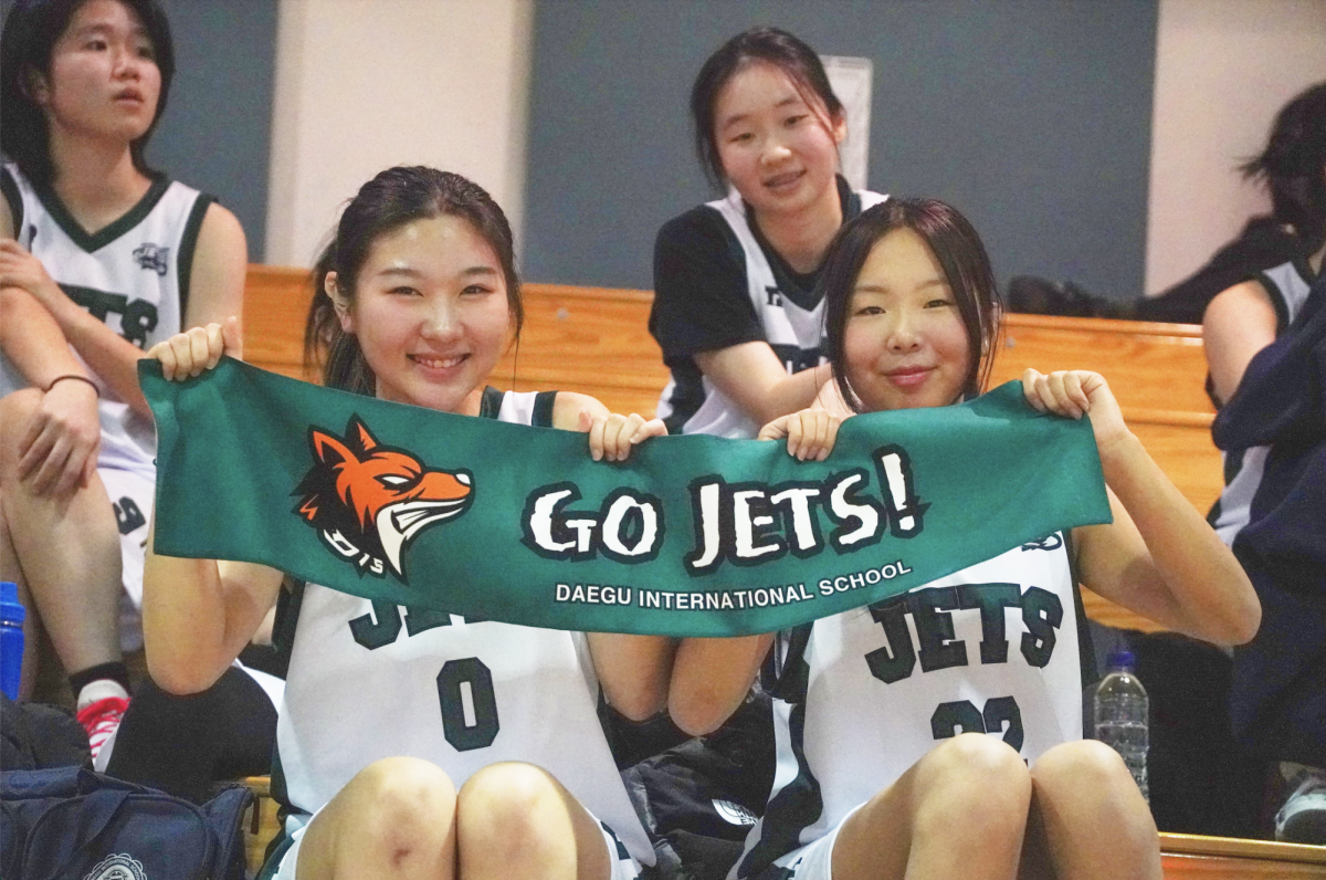 Sophomores Ellen Cho and Sophie Lee cheer enthusiastically from the sidelines, embodying the DIS spirit that unites the team and fans alike. Their energy and school pride contribute to the electrifying atmosphere, motivating the boys' team to push harder as the game unfolds. 